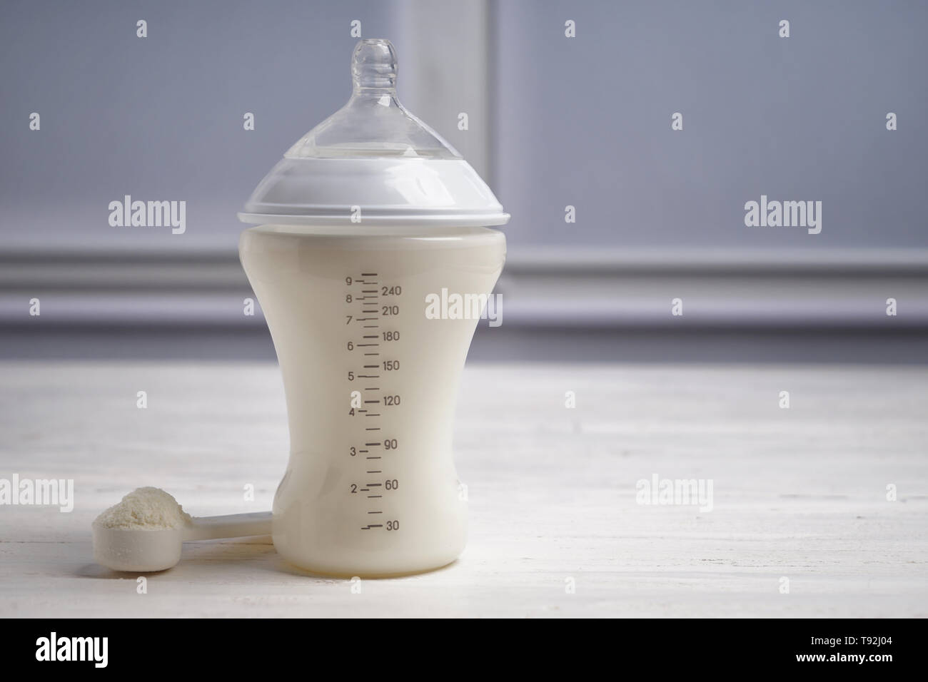 Die Flasche Milch für das Baby mit Pulver auf weißen Tisch Stockfoto