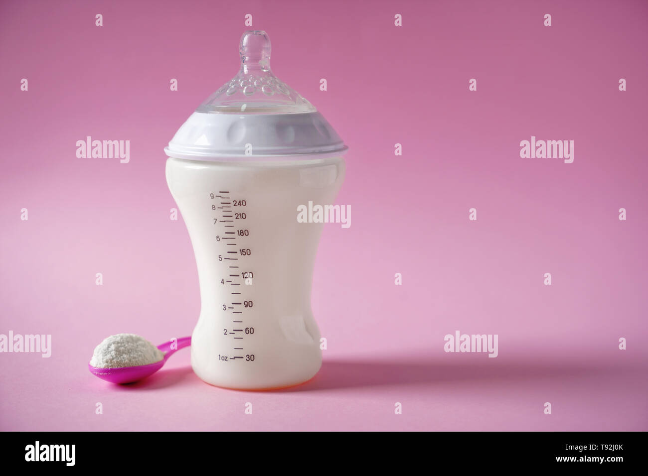 Die Flasche Milch für das Baby mit Pulver auf farbigen Hintergrund Stockfoto