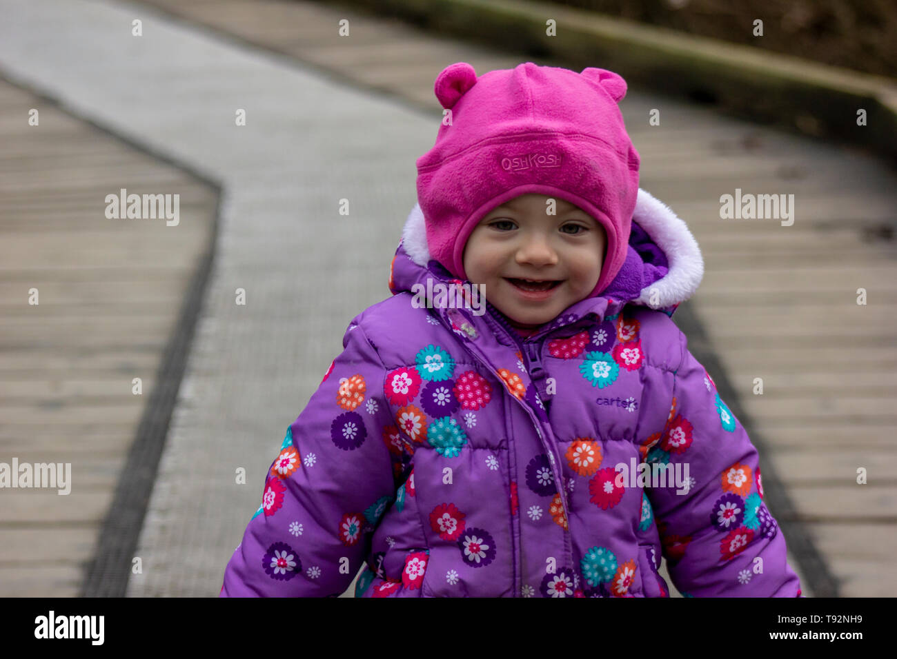 20 Monate altes Baby genießt das schöne Wetter. Für die kalten gebündelt. 1,5 Jahre altes Kleinkind wandern in Parks, wenn die Sonne scheint. Stockfoto
