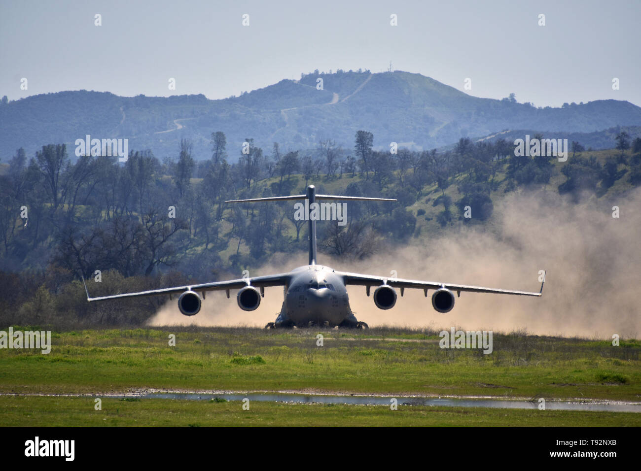 Die Besatzung des C-17 Globemaster von Travis Air Force Base, Kalifornien Praktiken Starts und Landungen am Fort Hunter Liggett, Kaliforniens Schoonover Schmutz strip Flugplatz, 18. März 2019. Die bodencrew war von der gemeinsamen Basis Elmendorf-Richardson, Alaska. Stockfoto