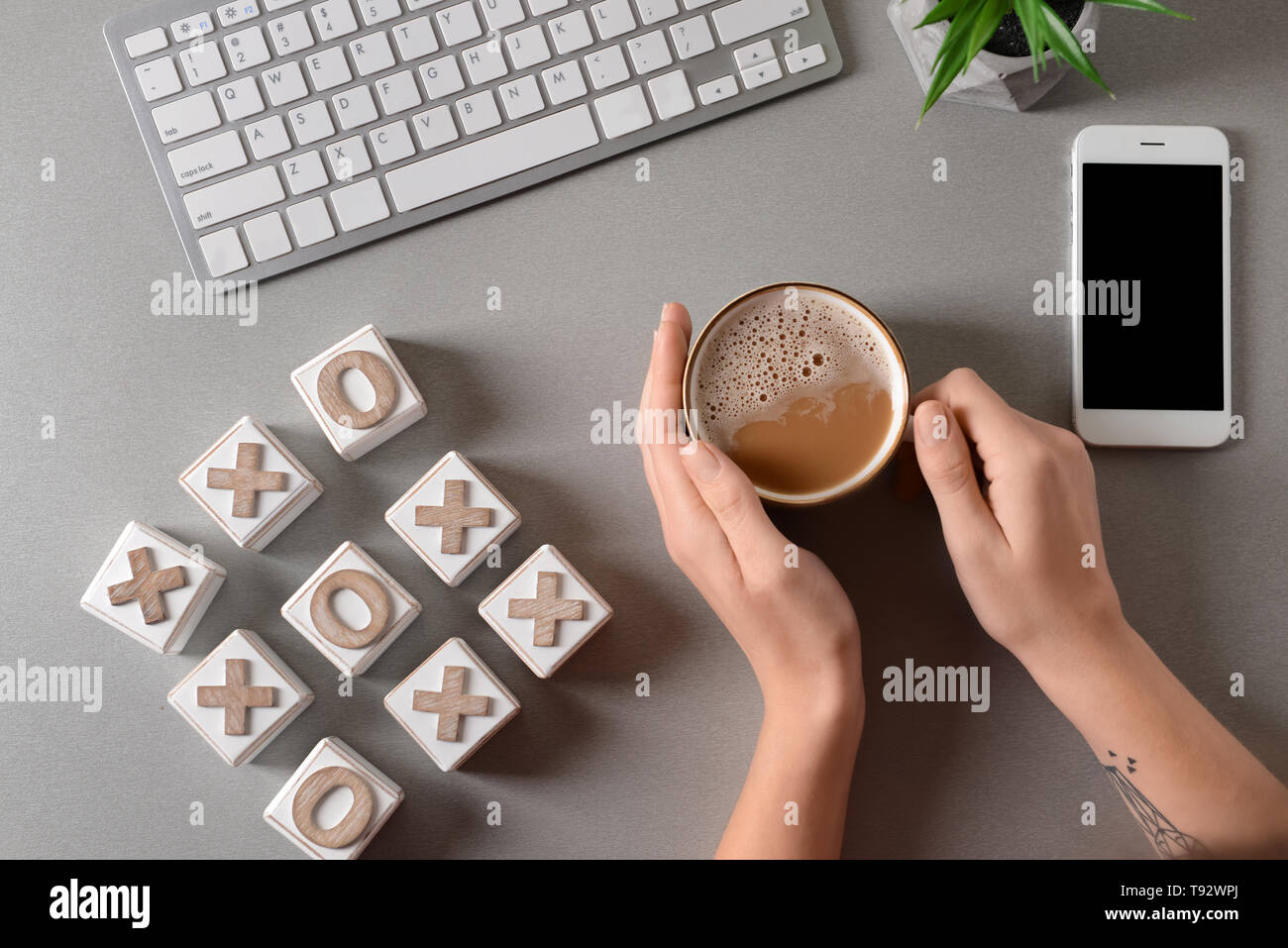 Frau trinkt Kaffee am Tisch mit Computer Tastatur und Tic Tac Toe Würfel,  Ansicht von oben Stockfotografie - Alamy