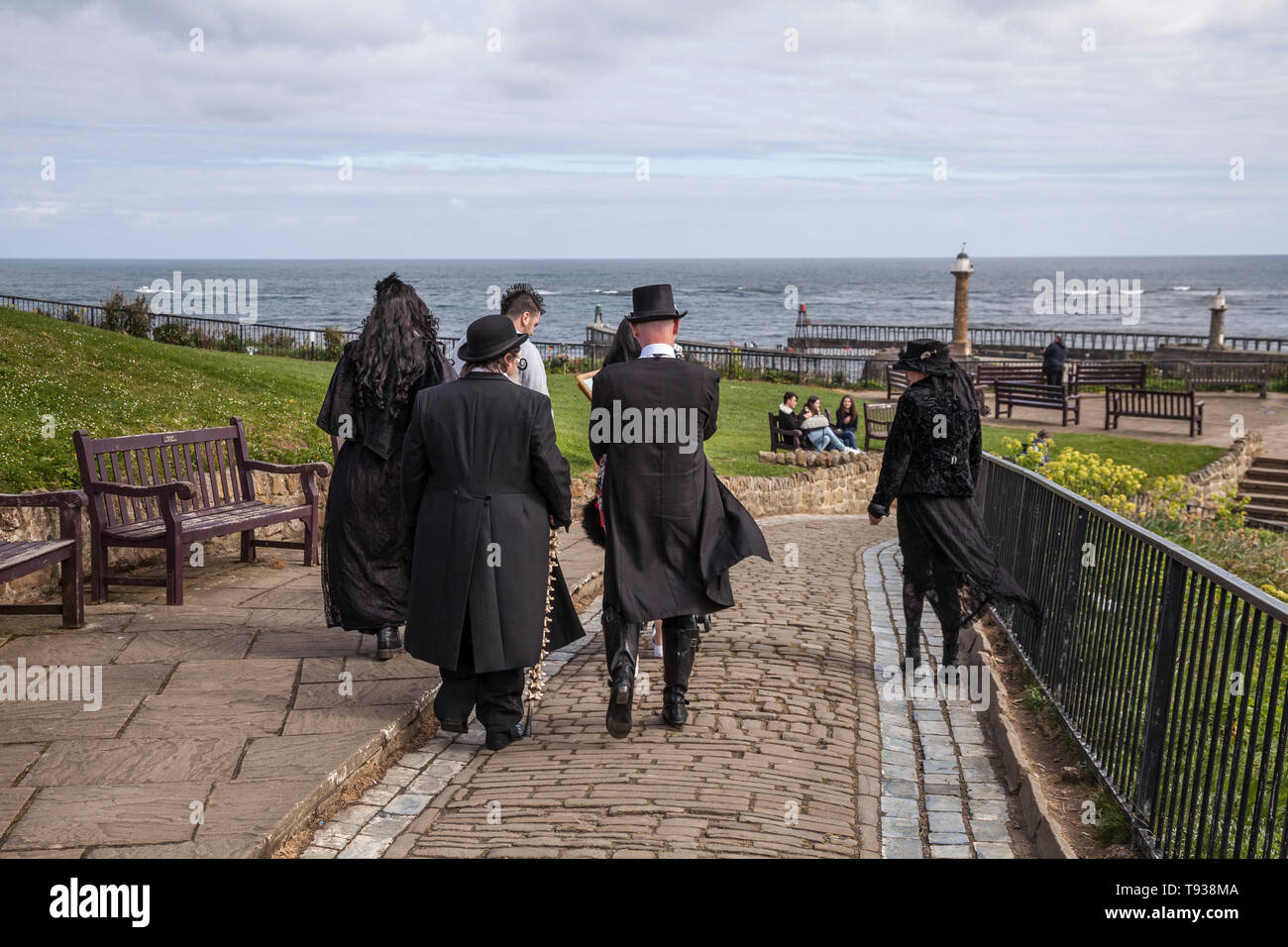 Eine Gruppe von Goten und Steampunks machen sich auf den Weg in Richtung Pier in Whitby, North Yorkshire, England, Großbritannien Stockfoto