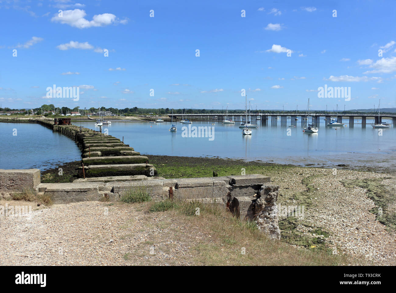 Langstone Hafen, Hampshire, England. Die Überreste von Hayling Billy mit Langstone Brücke in der Ferne. Stockfoto