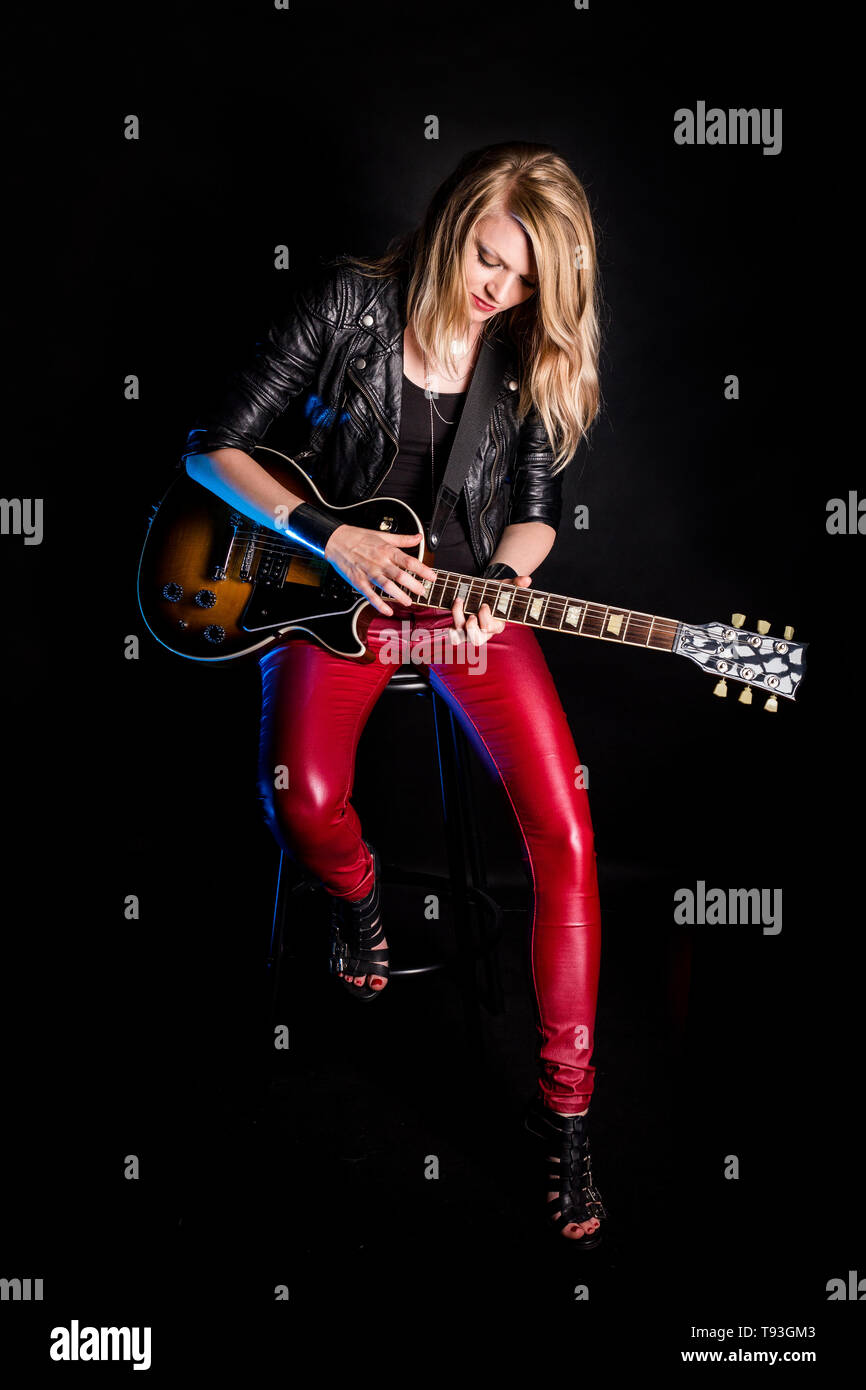 Rätselhaft, stilvolle blonde Mädchen Gitarrist spielt die E-Gitarre in Lederjacke. Frau Lehrerin zeigt, wie Song zu spielen. Weibliche Musiker Rock Star Stockfoto