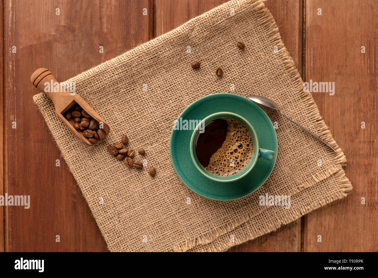 Eine Tasse schwarzer Kaffee mit gerösteten Kaffeebohnen, Schuß von oben auf einen dunklen Holzmöbeln im Landhausstil Hintergrund mit einem Platz für Text Stockfoto