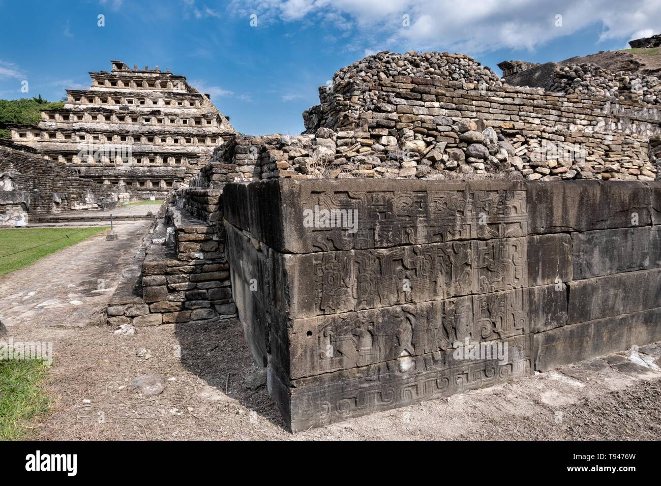 Geschnitzte relief Tafeln an den Wänden des Südens Ballcourt mit der Pyramide der Nischen auf der linken Seite an der Präkolumbianischen archäologischen Komplex von El Tajin in Tajin, Veracruz, Mexiko. El Tajín von 600 bis 1200 CE und während dieser Zeit zahlreiche Tempel, Paläste, ballcourts blühte, und die Pyramiden wurden von der Totonac Menschen erbaut und ist eines der größten und wichtigsten Städte der klassischen Ära der Mesoamerika. Stockfoto