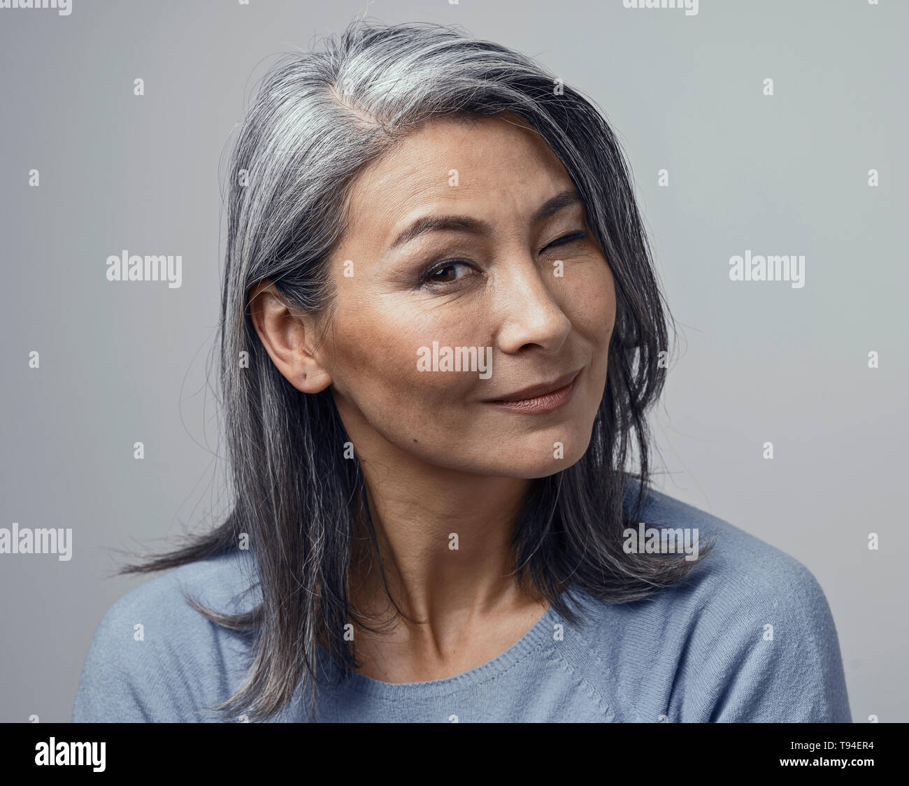 Charmante Asiatischen reife Frau lächelt Kamera Stockfoto