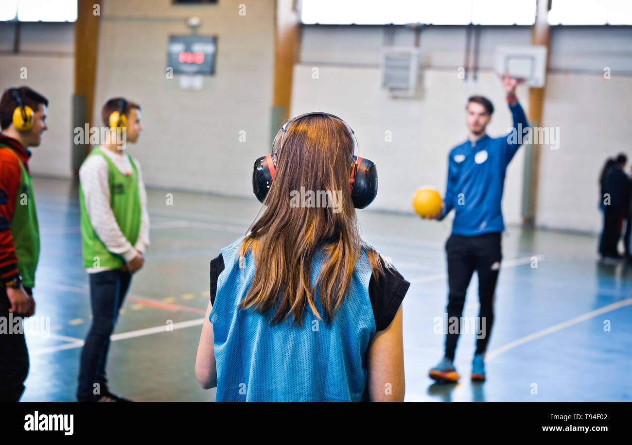 Behinderung Bewusstsein in der Schule. Junge Schüler Schülerinnen und Schüler üben ein Sport mit Ohrenschützer, um herauszufinden, wie es ist taub zu werden. Stockfoto