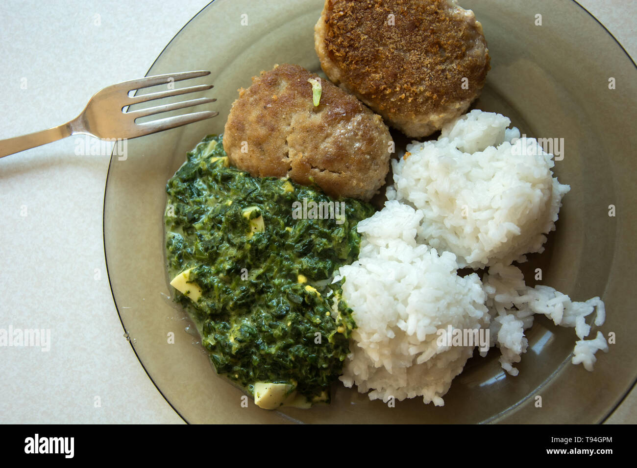 Auf einem Teller Teller, Hackfleisch Schnitzel, Reis und Spinat - Ansicht von oben Stockfoto