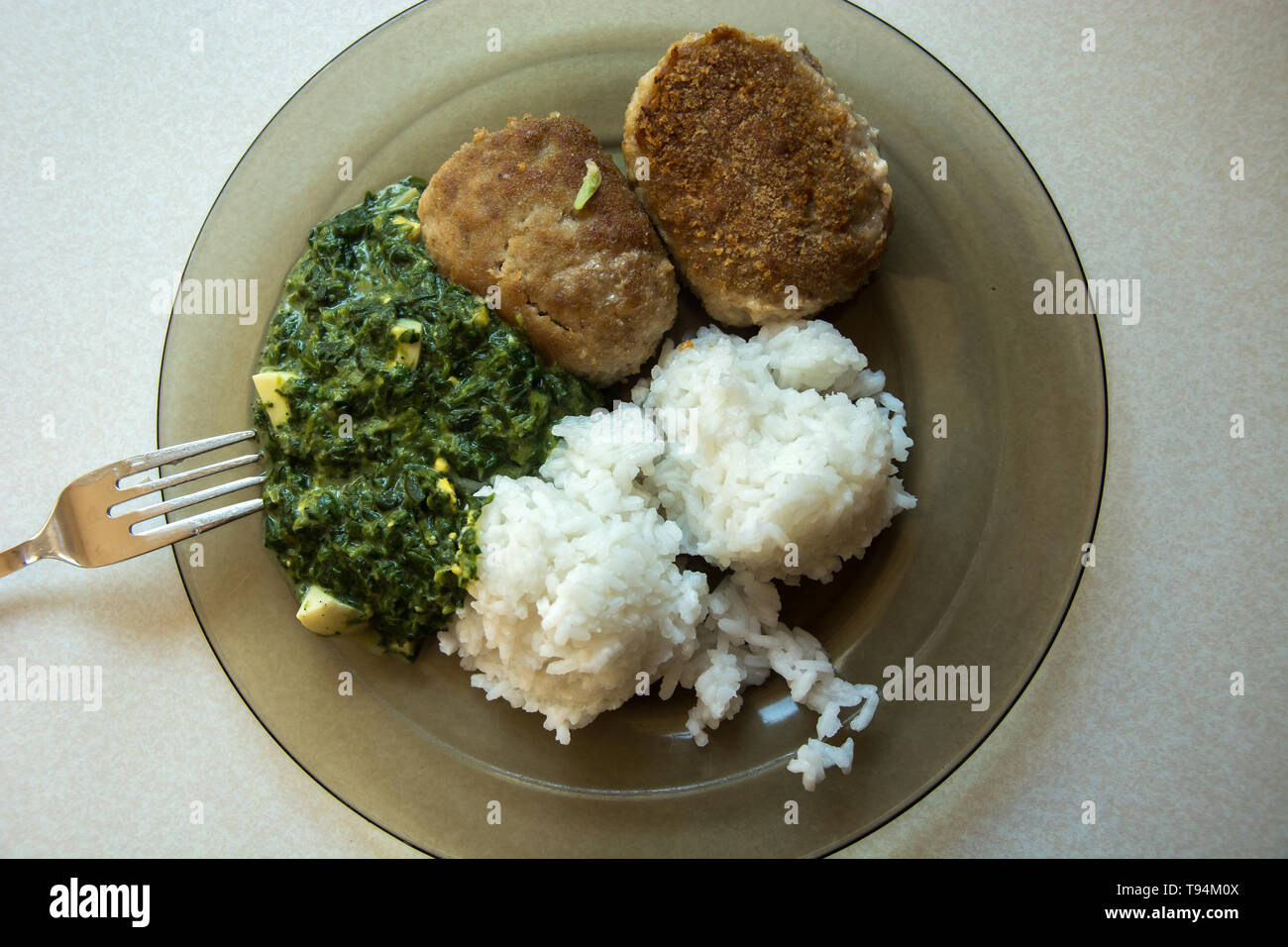 Teller auf eine Platte, die aus Hackfleisch/Schnitzel, Reis und Spinat - Ansicht von oben Stockfoto