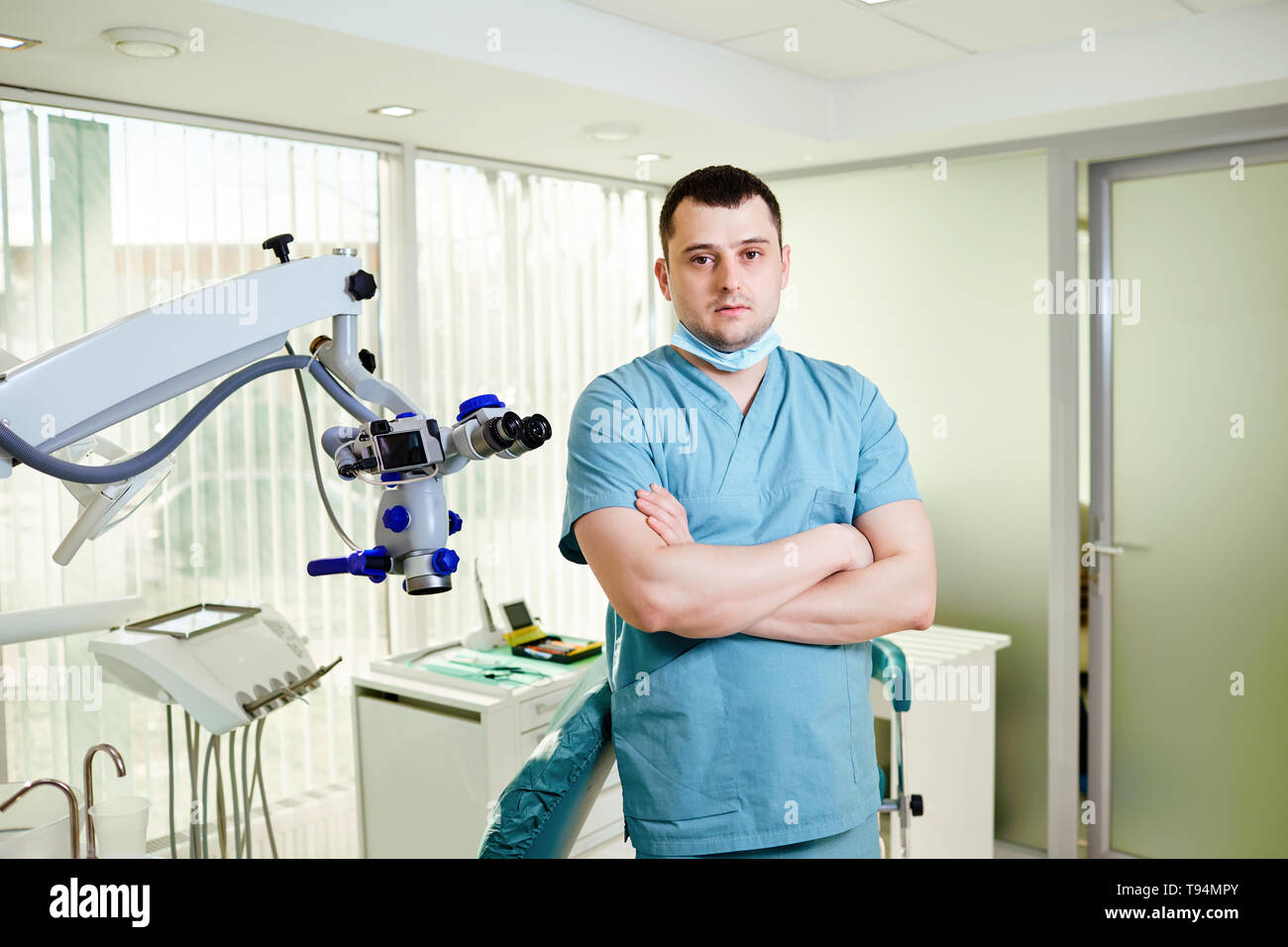 Ein männlicher Zahnarzt steht mit einem Mikroskop Stockfoto