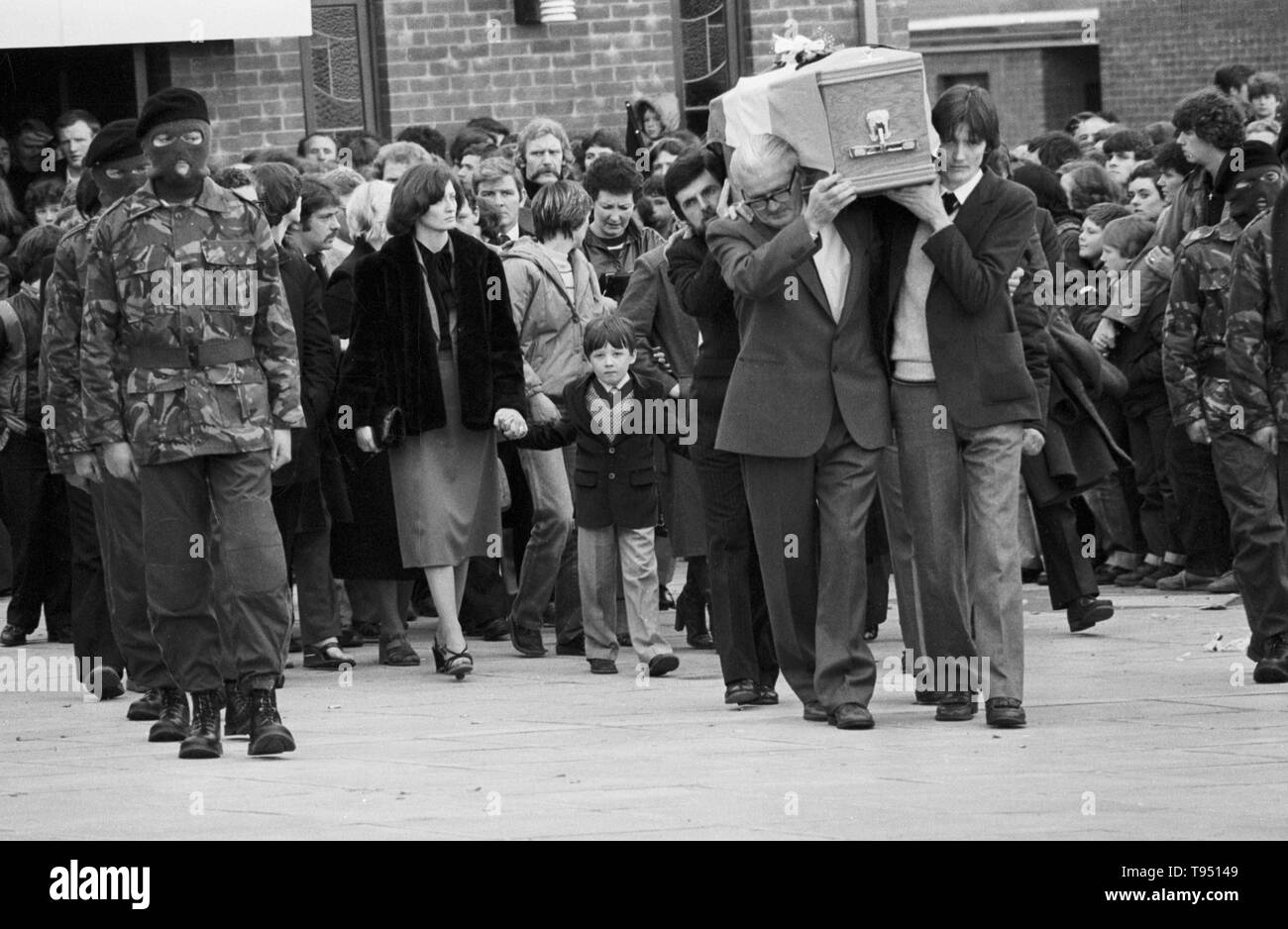 Der Sarg von Bobby Sands, MP wird durchgeführt von seinem Vater (links, Brille), sein Bruder (r) und Owen Carron (Schnurrbart), seine Wahl agent, von St Luke's Church auf der Twinbrook Immobilien, Belfast. Der Sarg ist Folgen von Schwester Bobby Sands, Marcella, der die Hand der Sands Sohn Gerald Holding, und andere Mitglieder der Familie auf dem Weg zur Beerdigung in Milltown Friedhof. Stockfoto