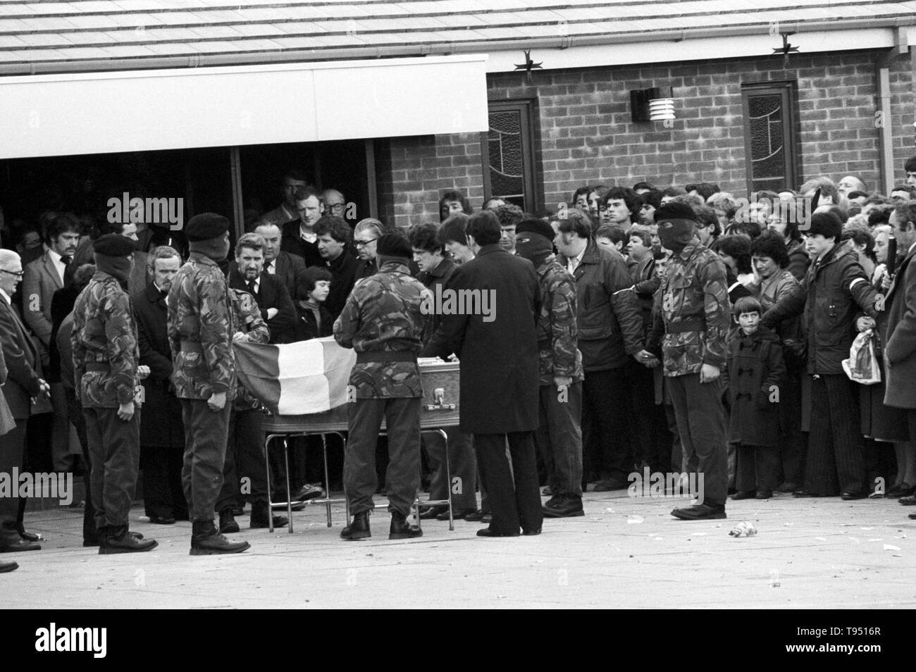 Maskiert und uniformierten Provisionals Drapieren der Sarg von Bobby Sands, MP mit der irischen Trikolore, vor dem Anfahren von St Luke's Church auf der Twinbrook Immobilien, Belfast, für die Bestattung in Milltown Friedhof. Stockfoto