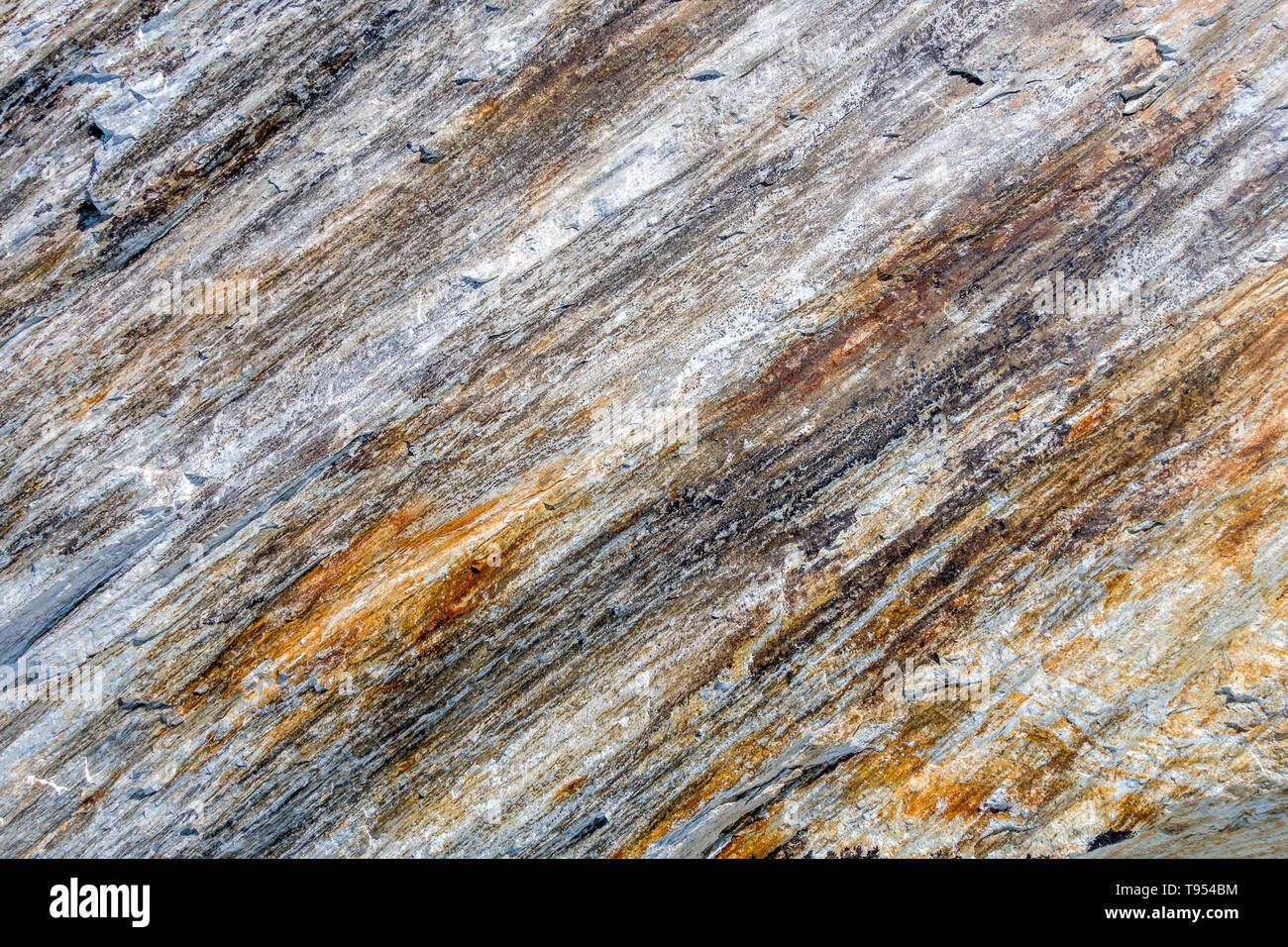 Alpine Felswand mit diagonal Schichten des Materials Rock Einlagen geben mehrere Farben und sichtbaren Eisen, um die strukturierte Oberfläche Stockfoto