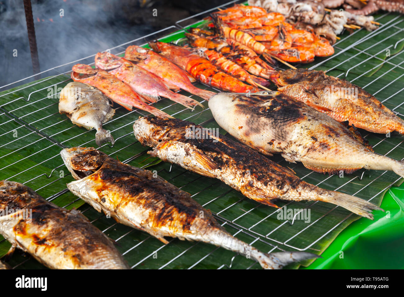 Auswahl an gegrilltem Fisch und Garnelen lag auf dem grünen Zähler der Marktplatz. Der Fischmarkt von Kota Kinabalu, Malaysia Stockfoto