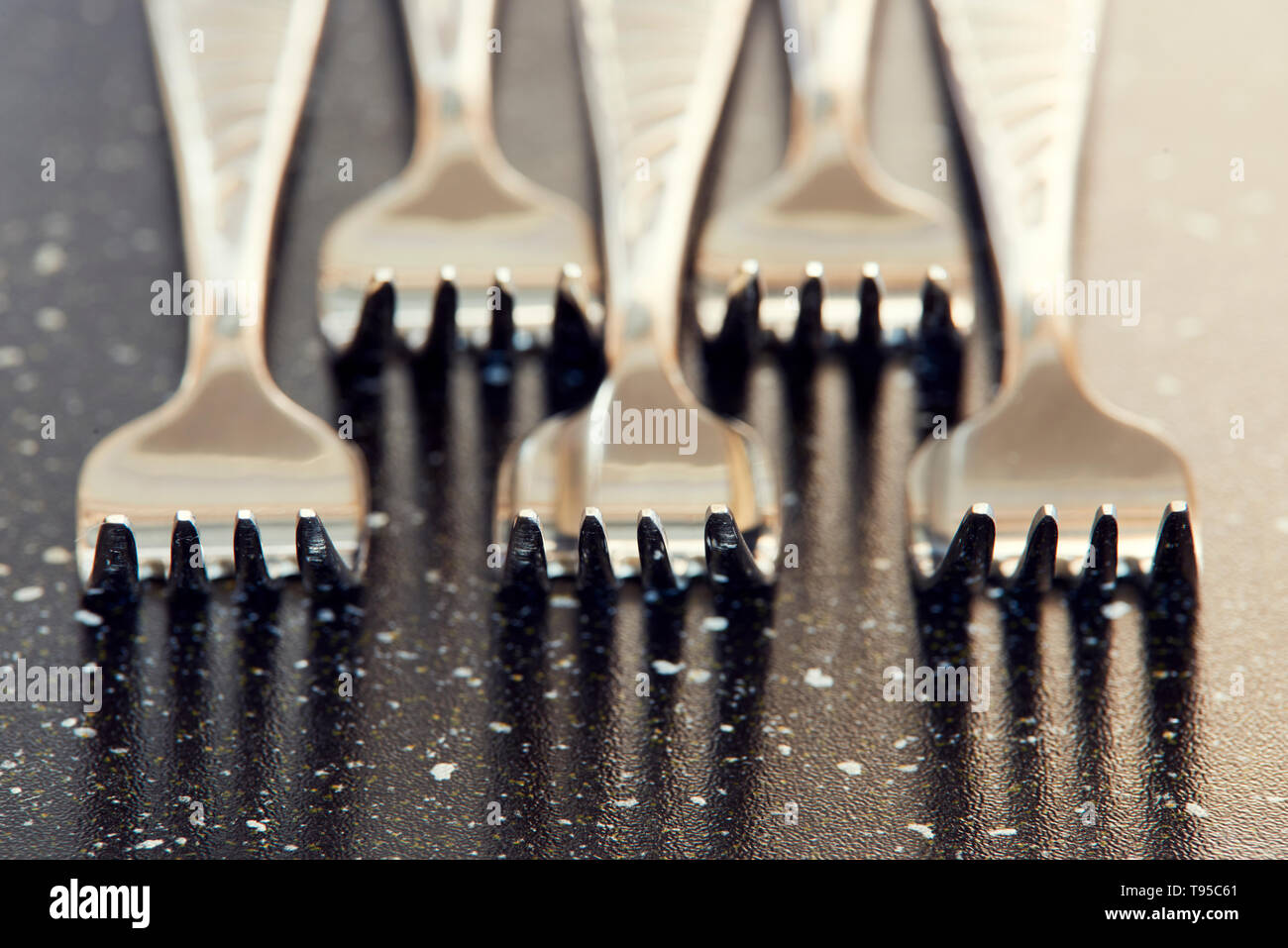 Stahl Gabel auf Schwarz. Makro Foto für Geschirr und Küche Thema. Makrofotografie von Silber Gabel am Tisch mit Schwerpunkt stapeln. Stockfoto