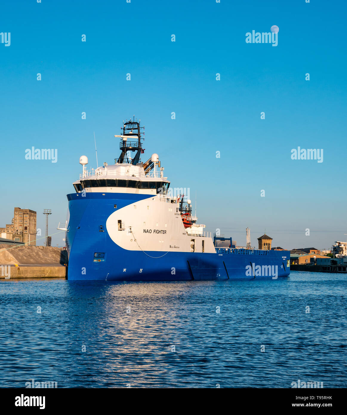 Leith Docks, Edinburgh, Schottland, Großbritannien, 16. Mai 2019. UK Wetter: ein sonniger Tag geht zu Ende über den Hafen in Leith mit einer Offshore Supply Schiff namens NAO-Kämpfer in den Hafen von den letzten Strahlen der Sonne mit einer fast vollständigen hellen Mond im blauen Himmel leuchtet Stockfoto