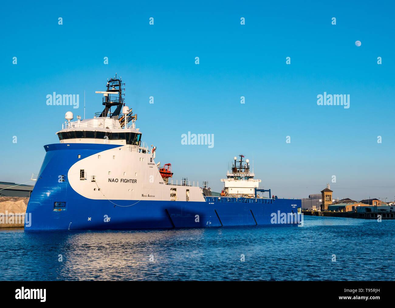 Leith Docks, Edinburgh, Schottland, Großbritannien, 16. Mai 2019. UK Wetter: ein sonniger Tag geht zu Ende über den Hafen in Leith mit einer Offshore Supply Schiff namens NAO-Kämpfer in den Hafen von den letzten Strahlen der Sonne mit einer fast vollständigen hellen Mond im blauen Himmel leuchtet Stockfoto