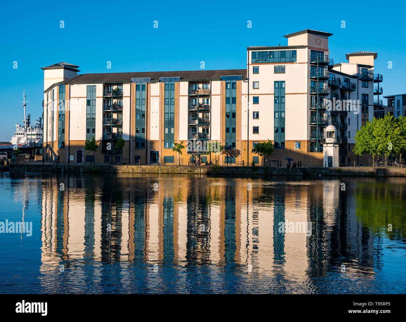 Leith Docks, Edinburgh, Schottland, Großbritannien, 16. Mai 2019. UK Wetter: ein sonniger Tag geht zu Ende über den Hafen in Leith mit Gebäuden am Ufer von den letzten Strahlen der Sonne spiegelt sich im Wasser des Leith Fluss lit Stockfoto