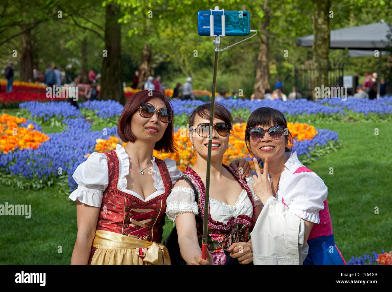 Keukenhof Holland, drei asiatische Frauen in Tracht, nehmen Sie einen selfie durch schöne bunte Blumen und Blüten im Frühjahr umgeben. Europa Stockfoto