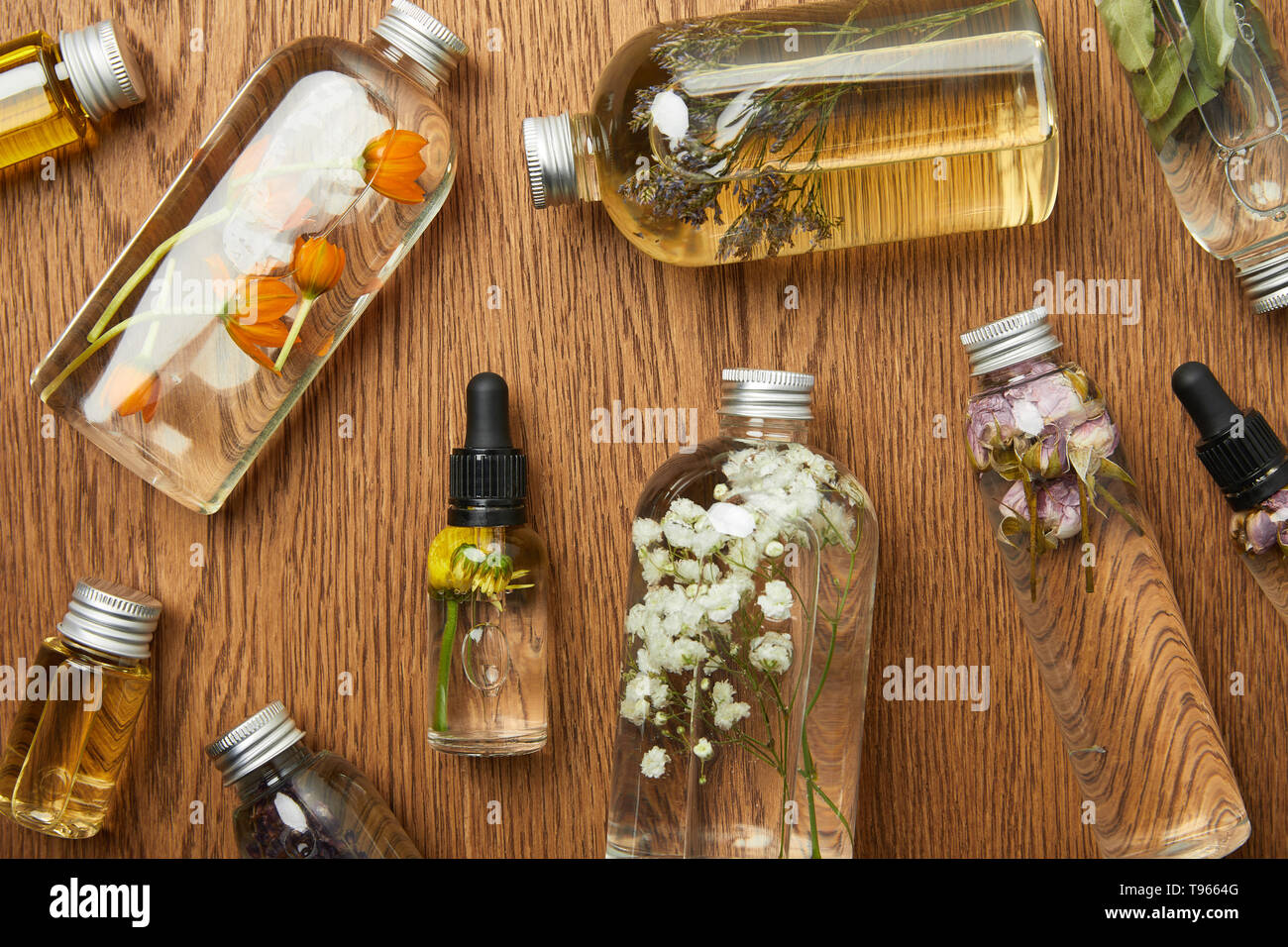Blick von oben auf die durchsichtigen Flaschen mit organischen Schönheit Produkte auf hölzernen Hintergrund Stockfoto