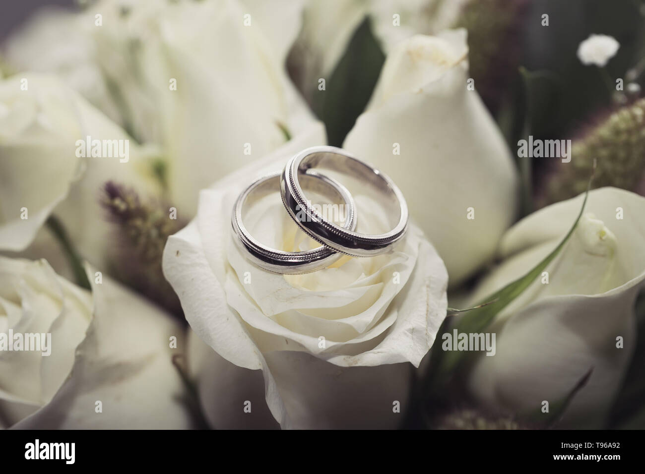 Eheringe auf natürlichem Rosenstrauß Stockfoto