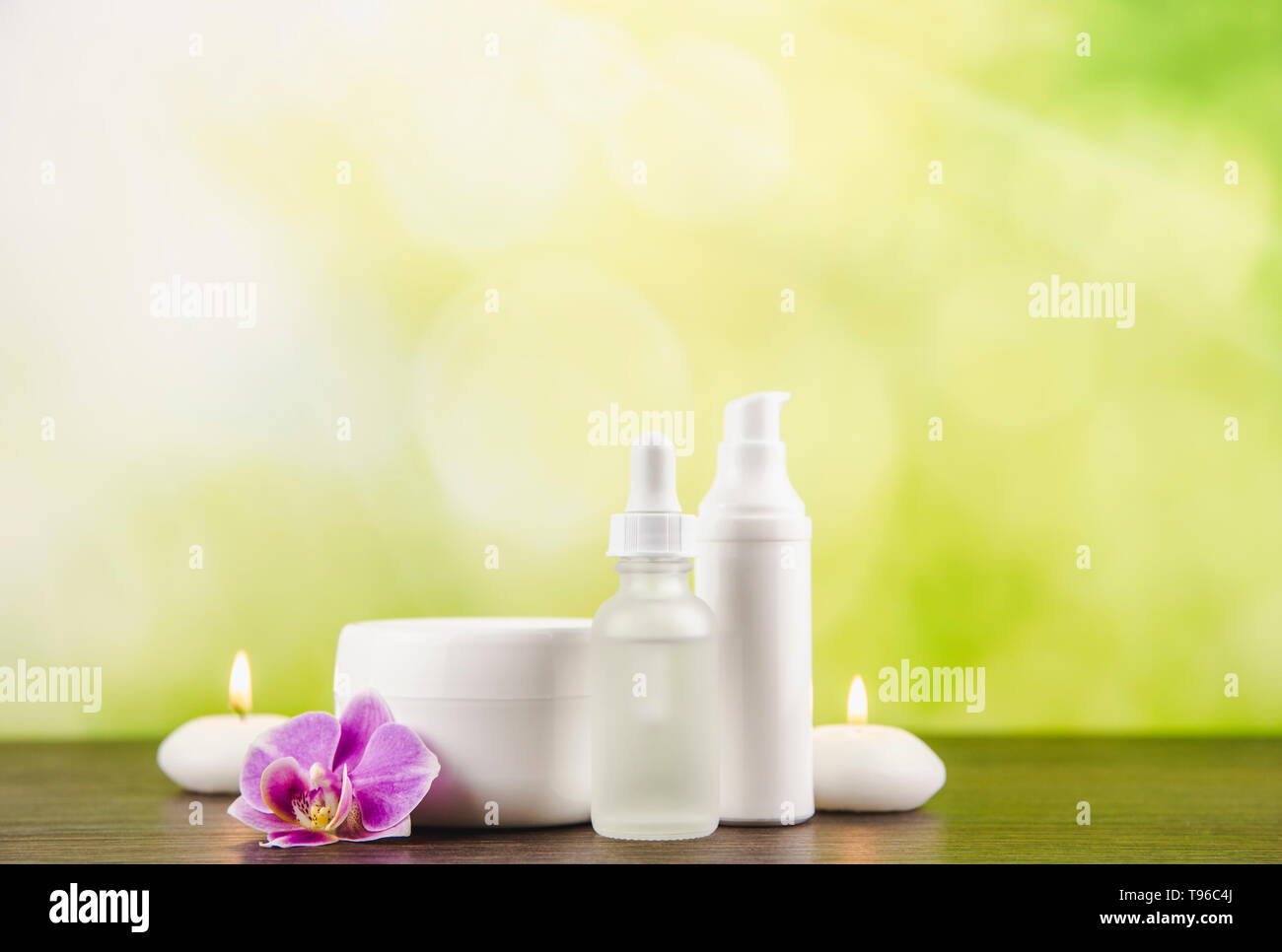 Verschiedene Beauty Produkte Container dunkelbraunen hölzernen Tisch mit grünem Hintergrund verschwommen Bokeh, kopieren. Stockfoto