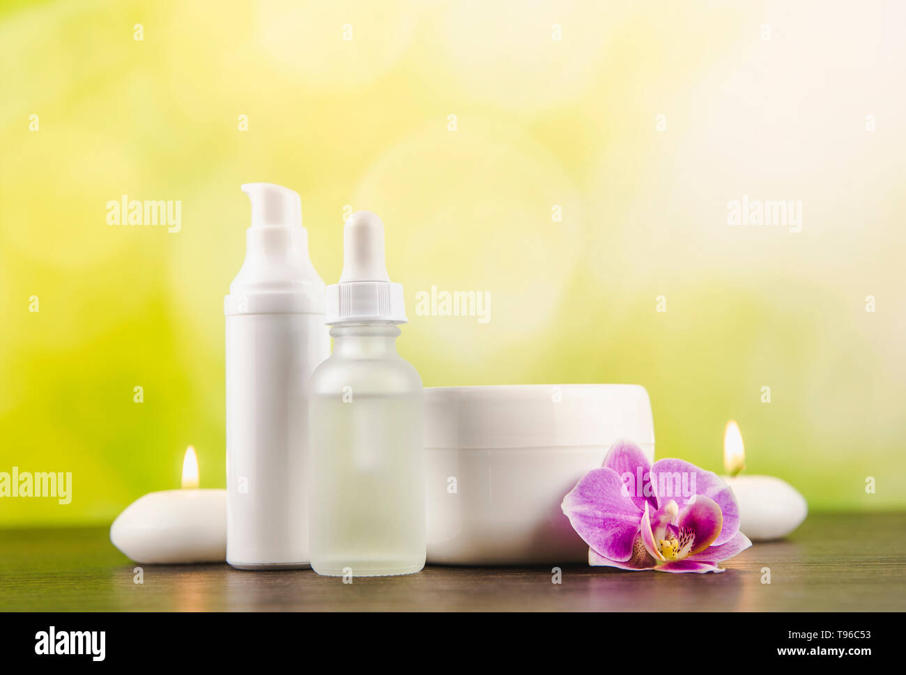 Verschiedene Beauty Produkte Container dunkelbraunen hölzernen Tisch mit grünem Hintergrund verschwommen Bokeh, kopieren. Stockfoto