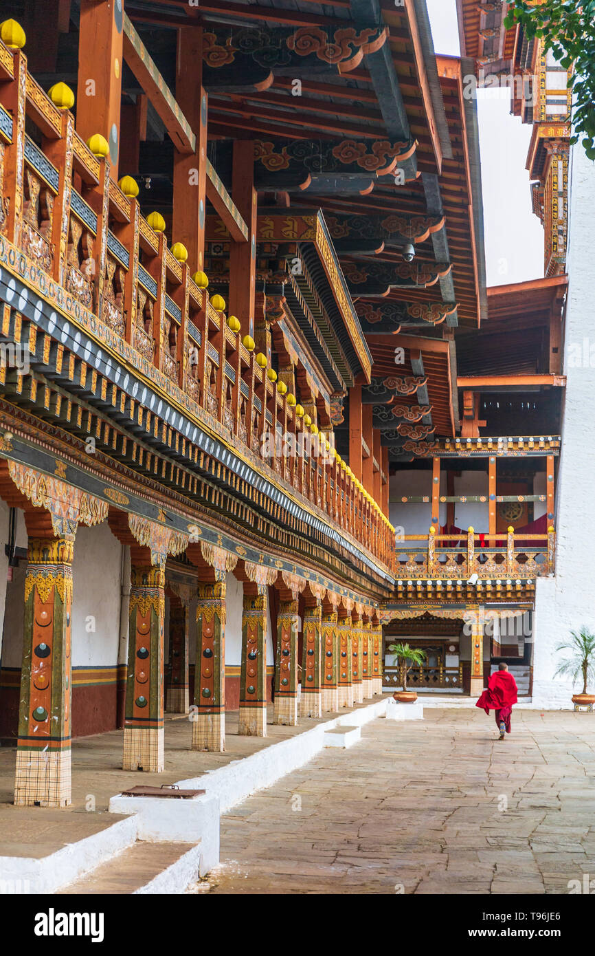 Buddhistischer Mönch, der durch den Hof des Klosters und Festung Punakha Dzong, Bhutan läuft Stockfoto