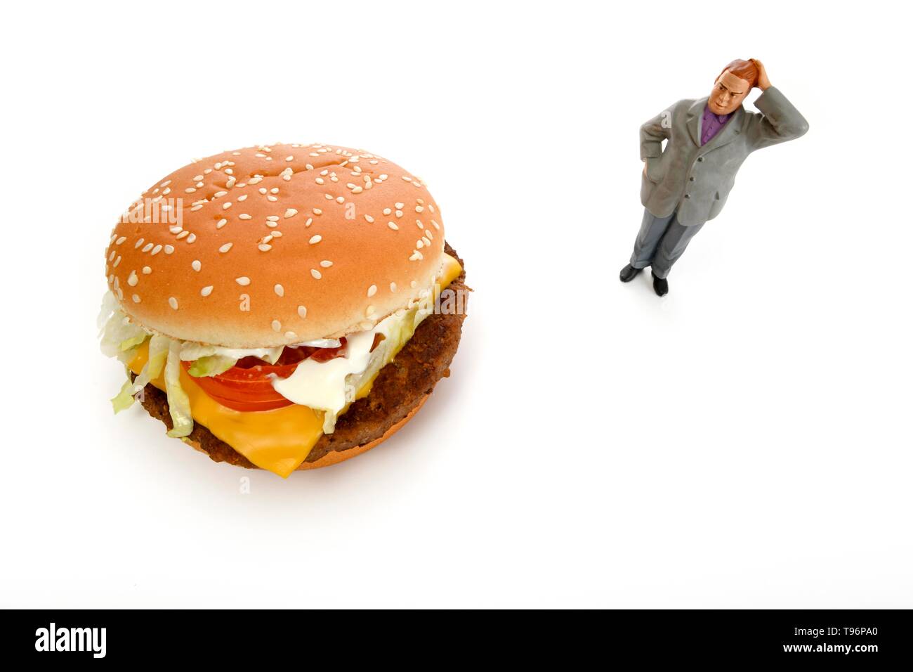 Symbol Bild Übergewicht, ungesunde Ernährung, nachdenkliche Figur vor der Cheeseburger, Deutschland Stockfoto