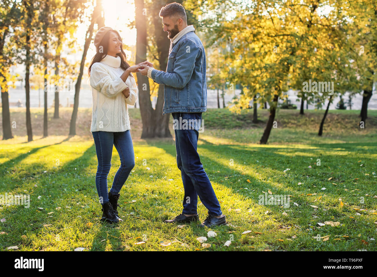 Junger Mann, Verlobungsring auf's Verlobte Finger im Herbst Park Stockfoto