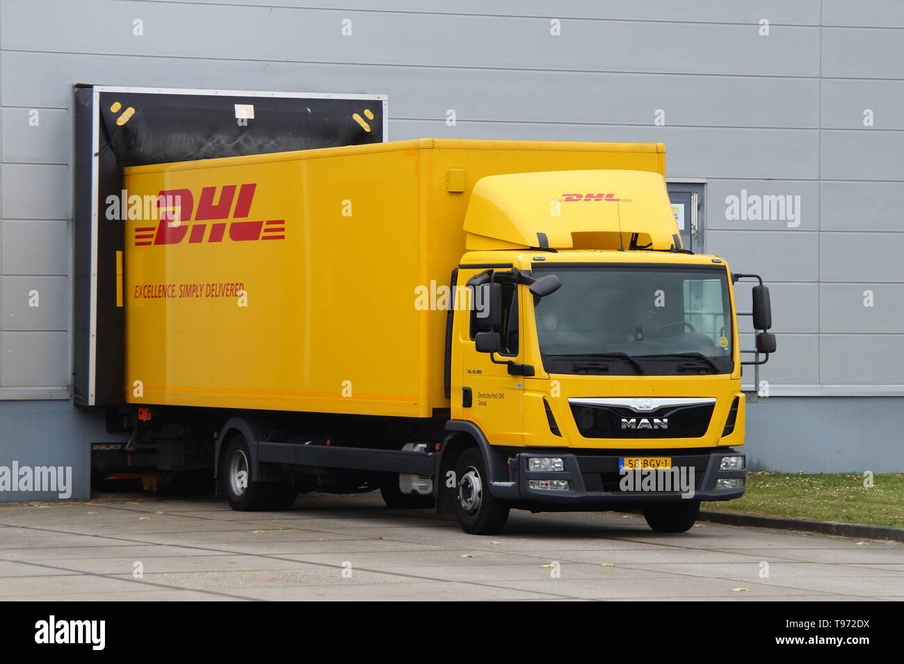 Almere, Niederlande - 24. Mai 2017: DHL Lieferung Lkw an einer Laderampe. Niemand in de Fahrzeug. Stockfoto