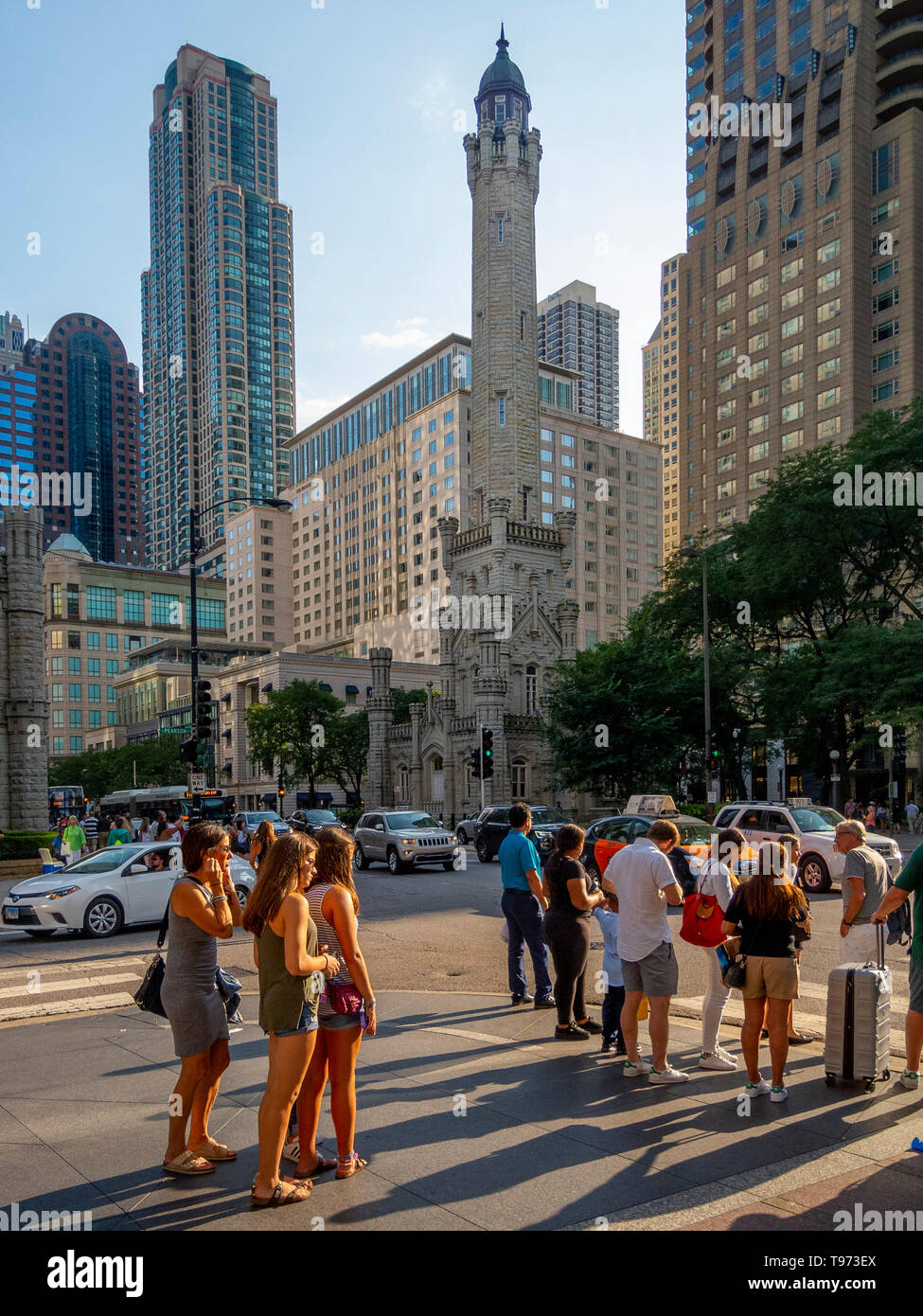 Nachmittag Sonne scheint auf Passanten neben dem Chicago Water Tower mit 806 North Michigan Avenue an der Magnificent Mile Shopping District in der Nähe von North Side community Bereich von Chicago, IL. Der Turm wurde gebaut eine große Wasserpumpe zu Haus, Wasser vom See Michigan zu zeichnen. 1869 erbaut, ist die älteste Wasserturm in den Vereinigten Staaten. Stockfoto