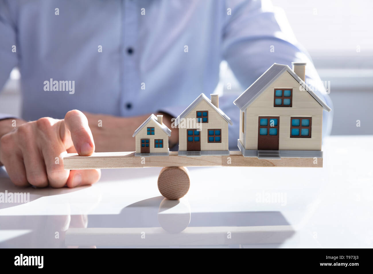 Parsons Hand Balancing Wachsenden Haus Modelle auf Holz- Wippe Stockfoto