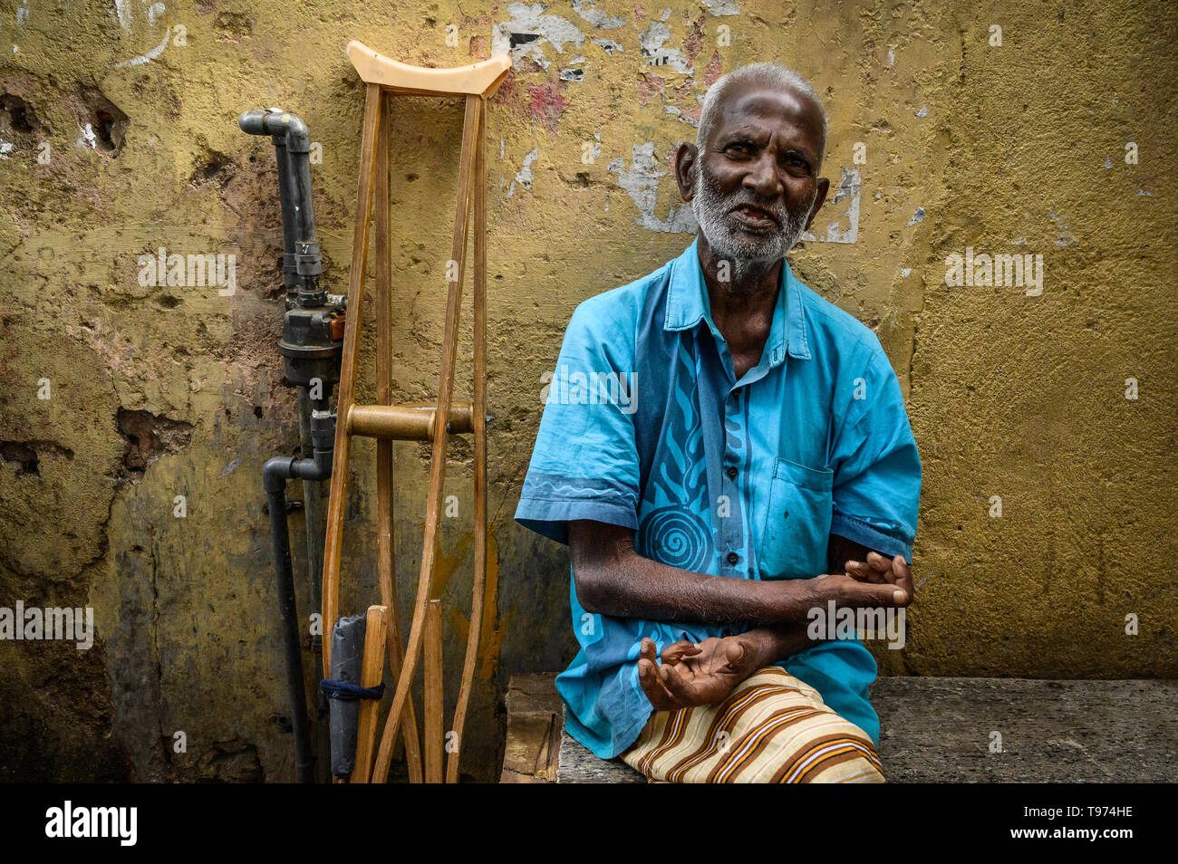 Portrait eines älteren Mannes mit seinen krücken hinter ihm, Kandy, Sri Lanka Stockfoto