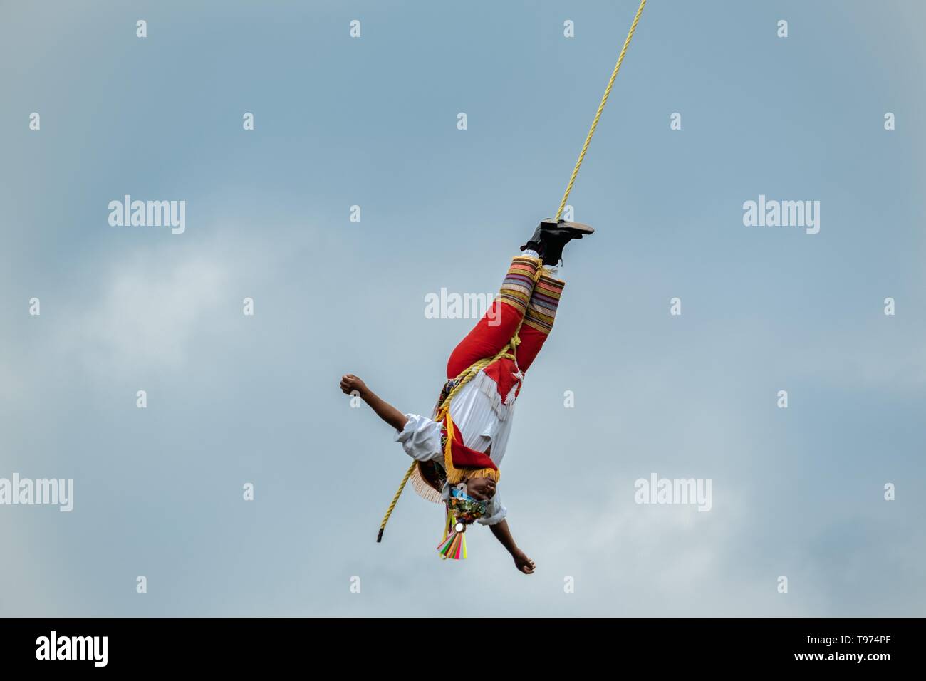 Ein volador führt die Heilige zeremoniellen Tanz der Voladores im Parque Takilhsukut im Präkolumbianischen archäologischen Komplex von El Tajin in Tajin, Veracruz, Mexiko. Die Danza de los Voladores ist eine indigene Totonac Zeremonie mit fünf Teilnehmern, ein 30-meter Mast klettern. Vier dieser Riegel Seile an ihren Hüften und Wind das andere Ende um die Spitze der Pole, um auf den Boden hinunter. Der fünfte Teilnehmer bleibt an der Spitze der Pole, Spielen, Flöte und eine kleine Trommel. Die Zeremonie wurde als ein Meisterwerk des mündlichen und immateriellen Erbes der Menschen eingeschrieben Stockfoto