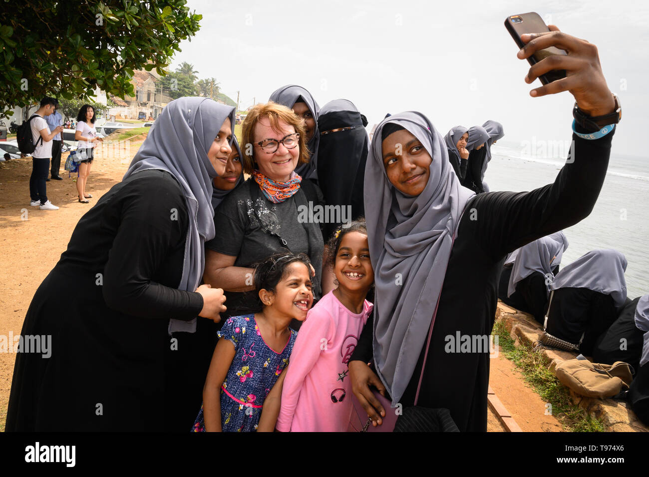 Ein fremder Besucher ihr Bild mit einheimischen Studenten, Galle, Sri Lanka, in Stockfoto