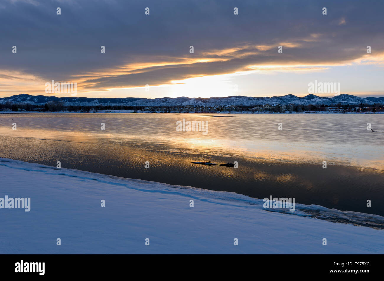 Stürmische Winter Lake - ein Sonnenuntergang von wintersturm Wolken über Schnee und Eis berg Stadt See bedeckt. Johnson Reservoir, Littleton, CO, USA. Stockfoto