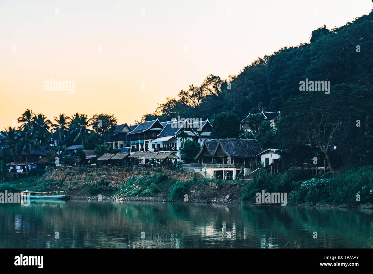 Nahaufnahme der traditionellen laotischen Fluss Stadt mit Holz- Architektur und Fischerboot. Ein kleines Dorf im dichten Dschungel von Laos. Stockfoto