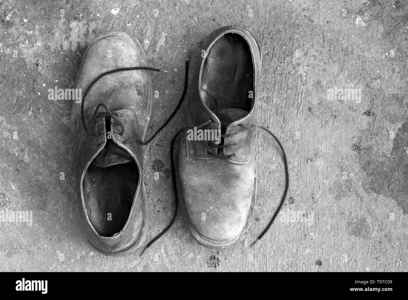 Zwei alte Schuhe in die entgegengesetzte Richtung platziert und von oben gesehen. Schwarz und Weiß. Kopieren Sie Platz Stockfoto