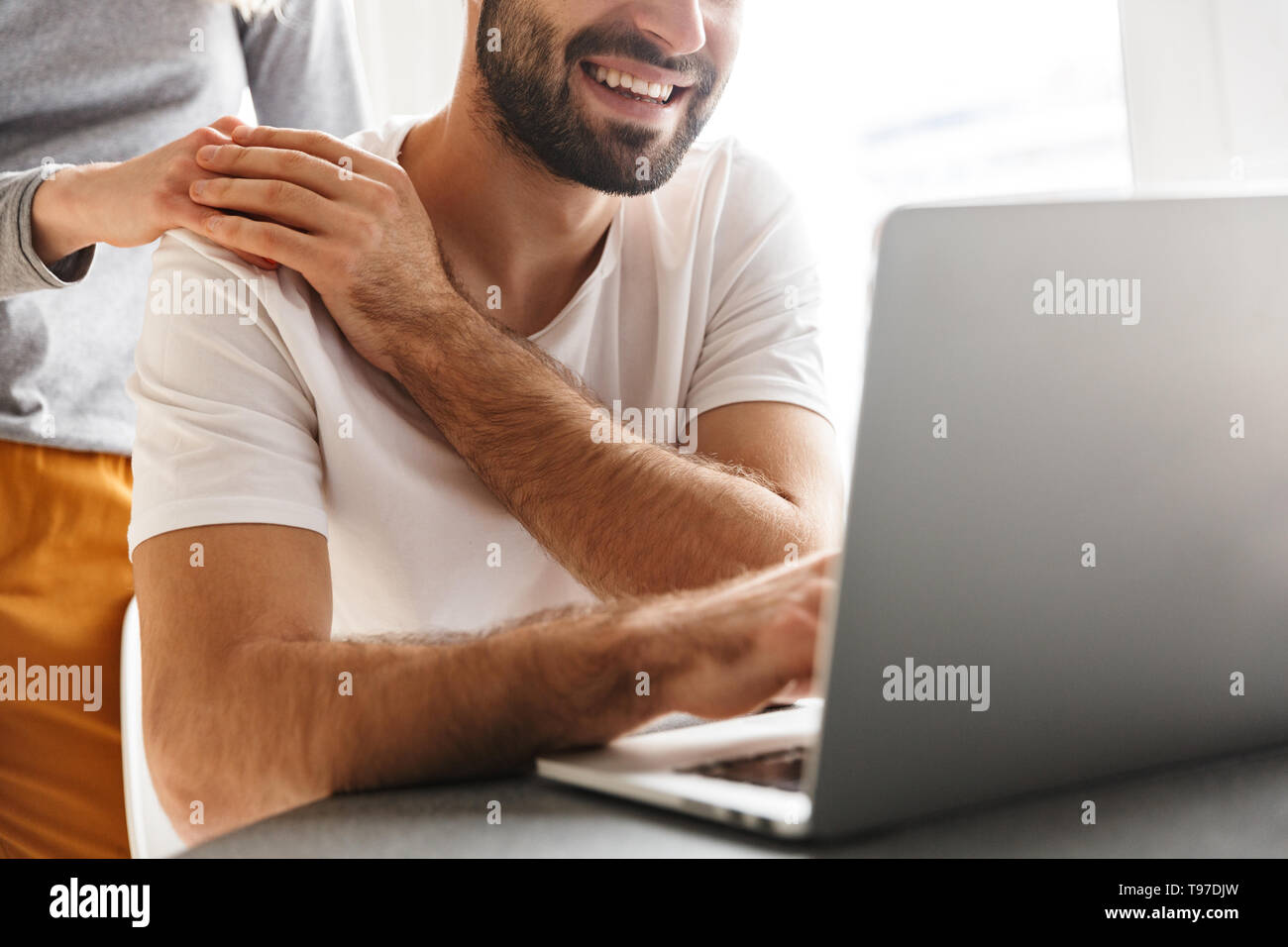 Zugeschnittenes Bild erstaunlich glückliches junges Paar in der Küche mit Laptop Computer sitzen. Stockfoto