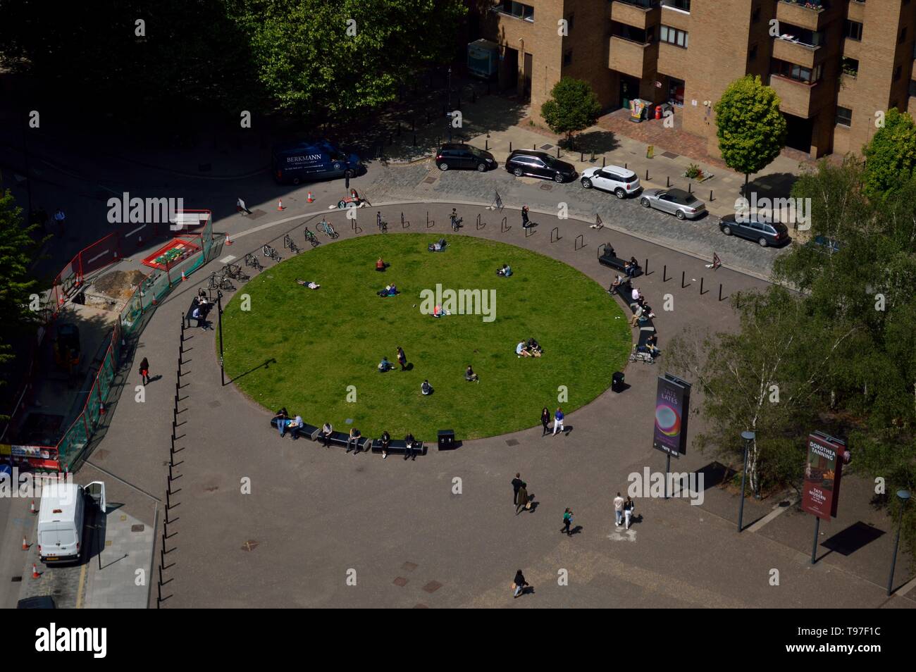 Menschen, die auf dem Rasen unter der Tate Modern entspannen, gesehen von oben, London, UK, 15. Mai 2019 Stockfoto