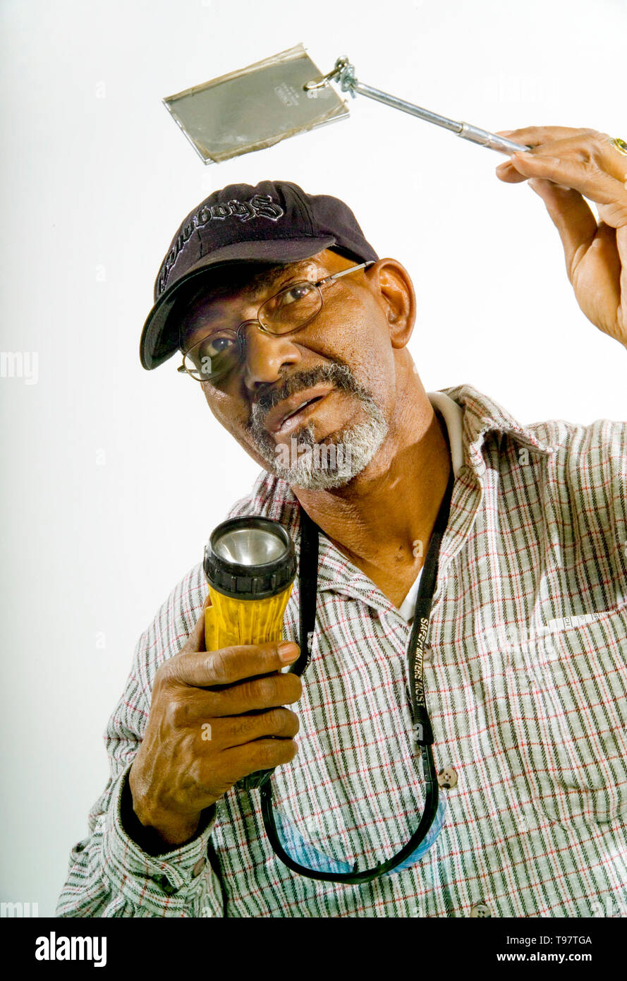 Eine Eisenbahn Carman demonstriert die Taschenlampe und Spiegel verwendet, um die Integrität von Bremssystemen auf Waggons in Los Angeles zu prüfen. Stockfoto