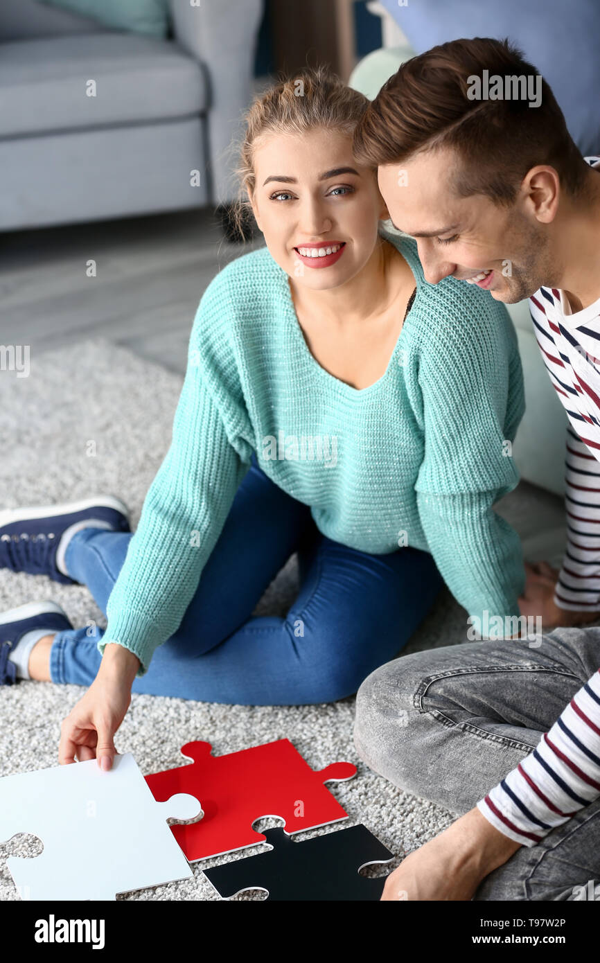 Junges Paar Montage Puzzle auf dem Boden zu Hause Stockfoto