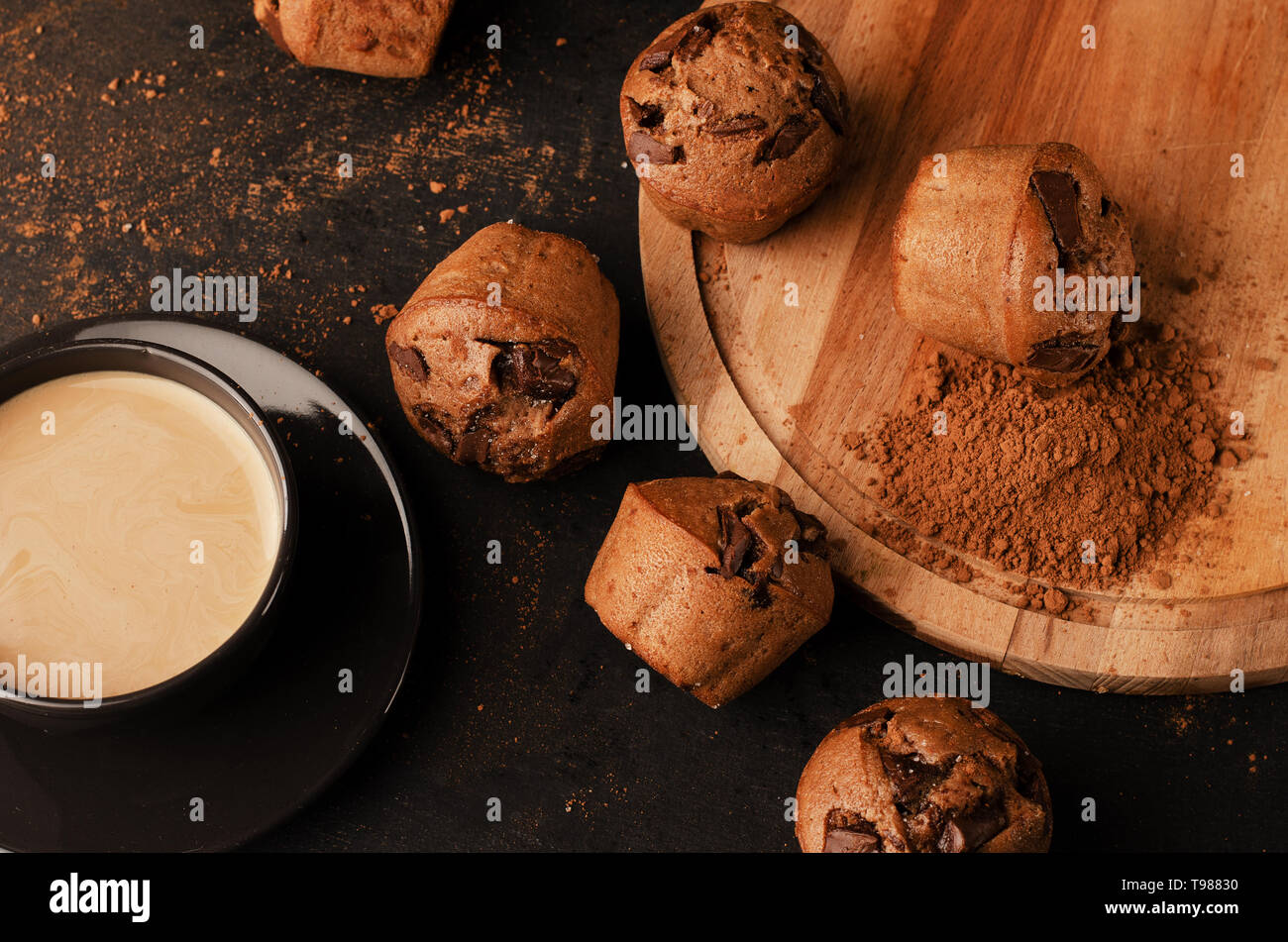 Fach mit leckeren Muffins und Kaffee auf schwarz Tabelle Stockfoto