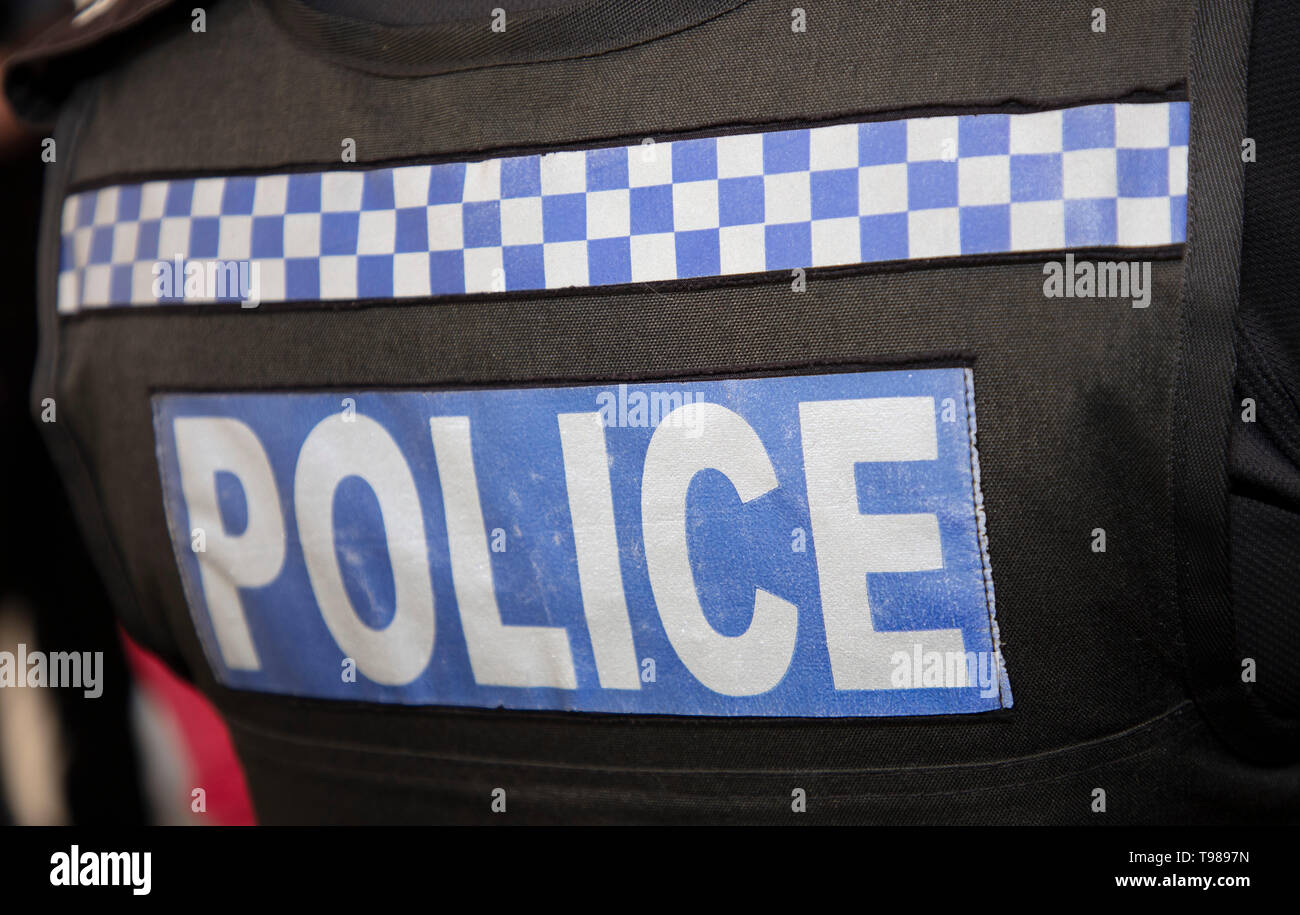 Polizei und Blau und Weiß Karomuster auf der Rückseite der Polizei stab Nachweis Jacke geschrieben Stockfoto
