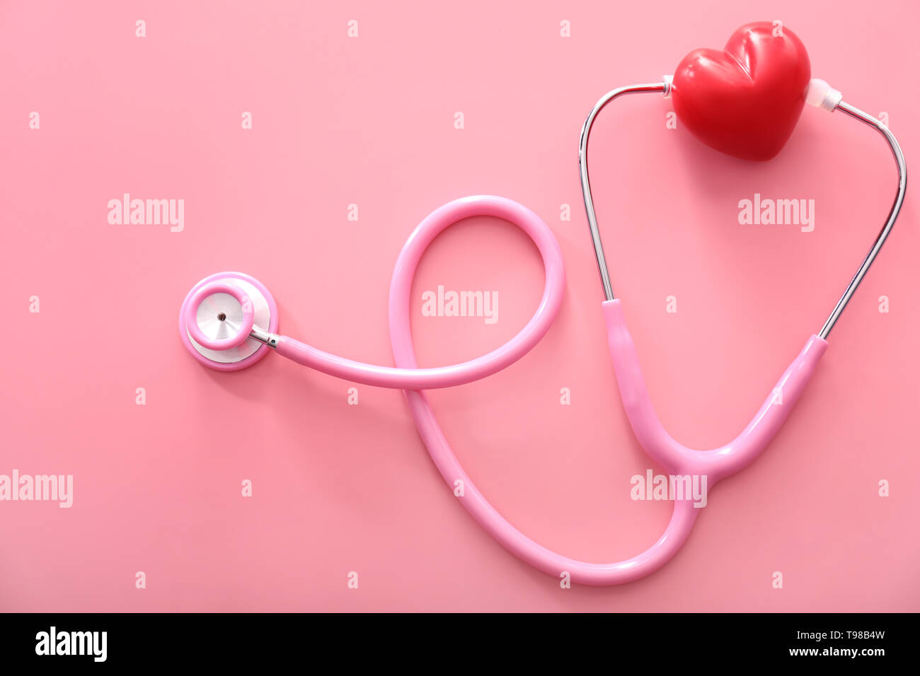 Medizinische Stethoskop mit roten Herzen auf farbigen Hintergrund. Gesundheit Konzept Stockfoto