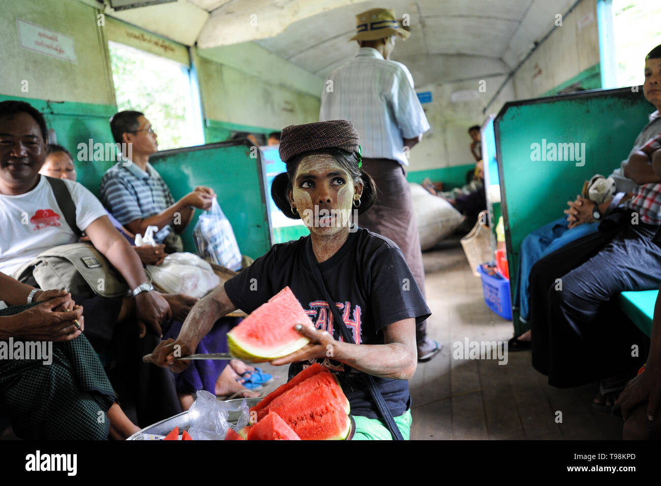 02.09.2013, Yangon, Myanmar - eine Frau verkauft frische Wassermelone in einem Zugabteil der Ringbahn. Ihr Gesicht ist mit den typischen Tha verschmiert Stockfoto