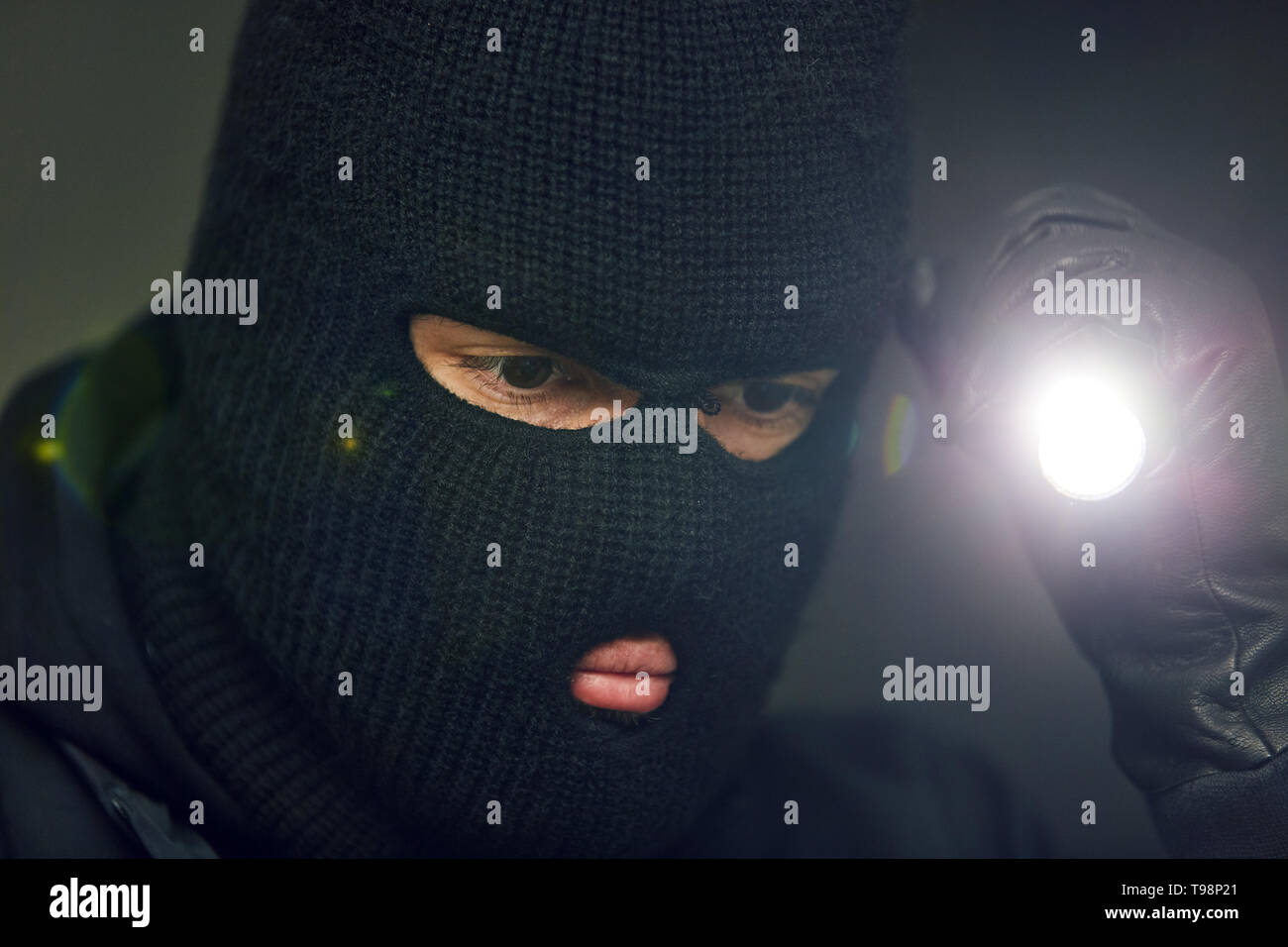 Einbrecher oder Dieb auf der Suche nach Wertsachen mit Taschenlampe Stockfoto