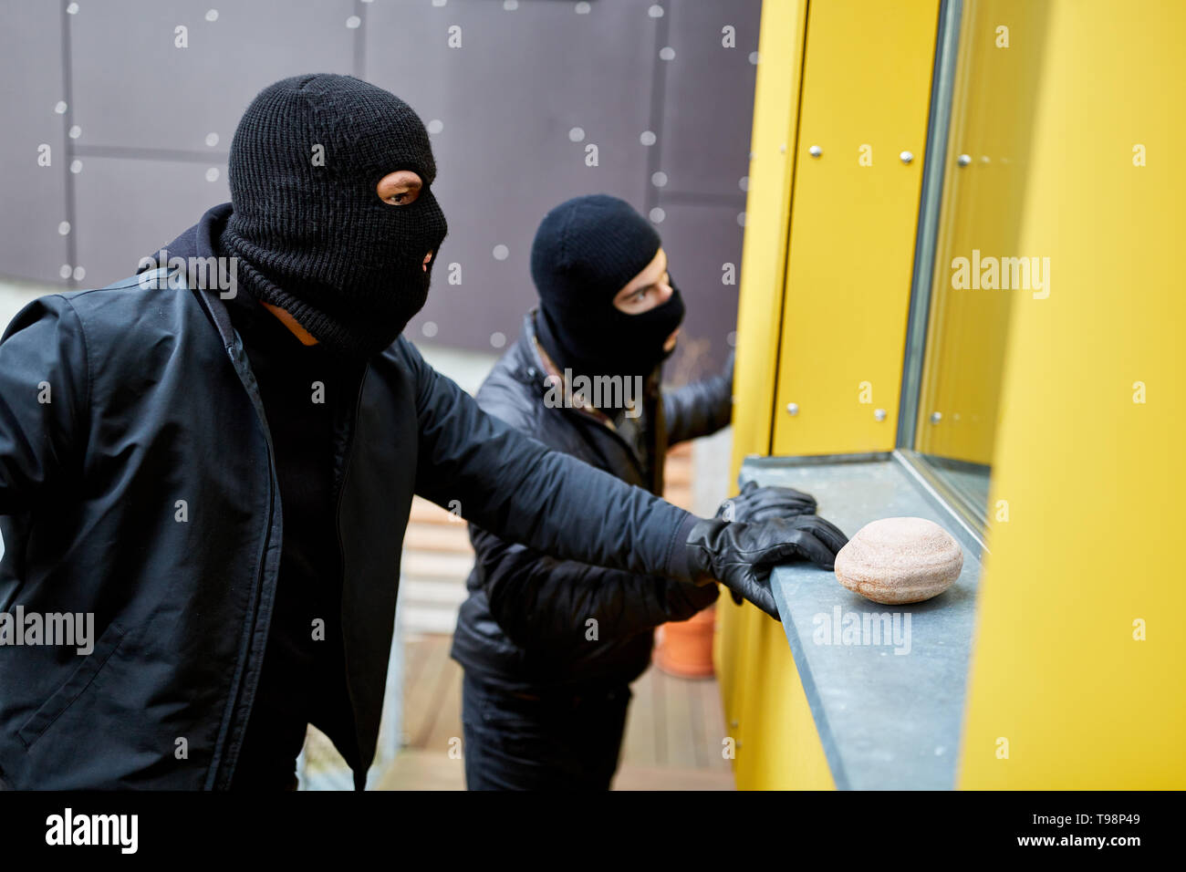 Zwei Einbrecher beobachten Sie die Fenster des Einfamilienhauses Stockfoto